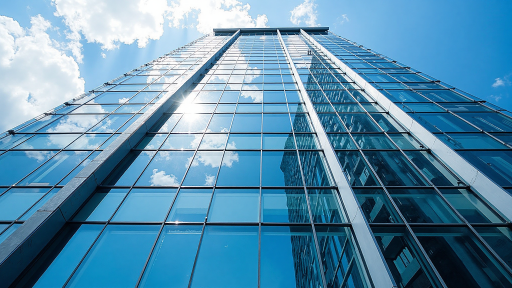 公司大楼外观，现代化办公楼建筑，玻璃幕墙设计，周围绿化环境优美，蓝天白云背景